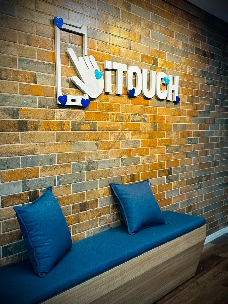 O logotipo da iTouch na parede de tijolos